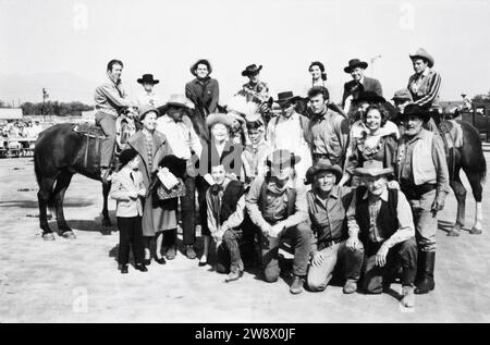 CLINT EASTWOOD in group photo circa 1963 candid at the time he was appearing in the TV series RAWHIDE at a cowboy / western show for disabled children with CLU GULAGER on horse at far left Stock Photo