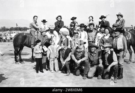 CLINT EASTWOOD in group photo circa 1963 candid at the time he was appearing in the TV series RAWHIDE at a cowboy / western show for disabled children with CLU GULAGER on horse at far left Stock Photo