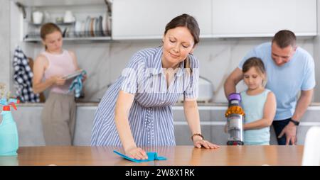 Mom is dusting the table. Father with children vacuuming room Stock ...