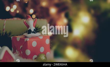 Santa claus doll on gift box with christmas lights with text space Stock Photo