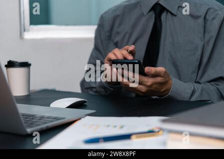 man using  mobile smartphone working and digital online computer laptop at office Stock Photo