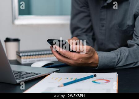 man using  mobile smartphone working and digital online computer laptop at office Stock Photo