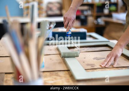 Carpenter painting furniture in her workshop, close-up Stock Photo