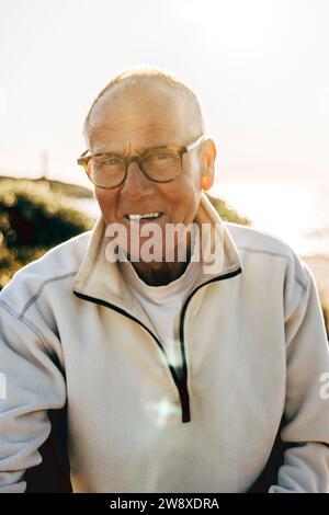 Portrait of smiling senior man wearing eyeglasses on sunset Stock Photo