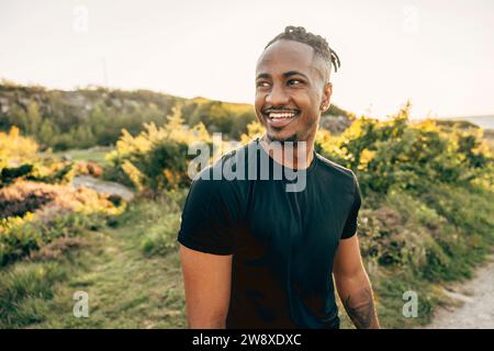 Happy young man looking away at beach Stock Photo