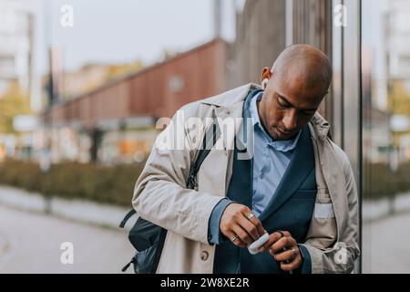 Businessman with shaved head wearing wireless in-ear headphones Stock Photo