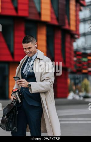 Happy businessman using smart phone while standing at street Stock Photo