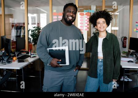 Portrait of happy male and female colleagues standing together at office Stock Photo
