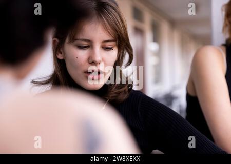 Young woman looking down with friend in balcony Stock Photo