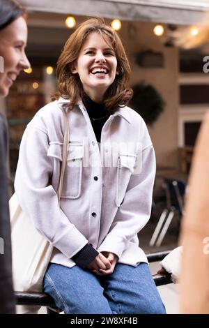 Happy young woman contemplating while sitting on railing Stock Photo