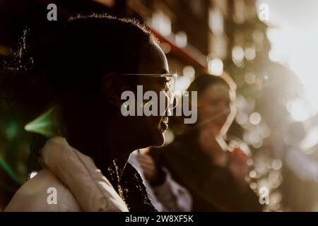 Smiling young woman wearing eyeglasses in city during sunset Stock Photo