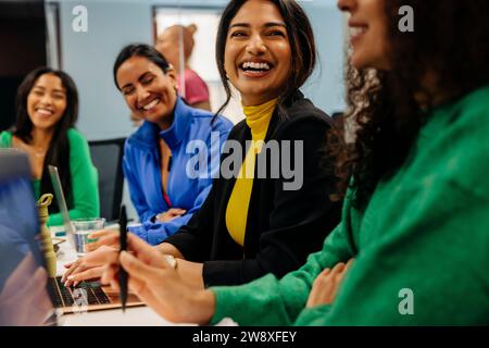 Happy female business professional with colleague during meeting at work place Stock Photo