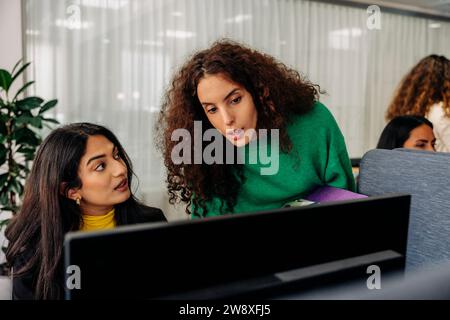 Focused female entrepreneurs working together at office Stock Photo
