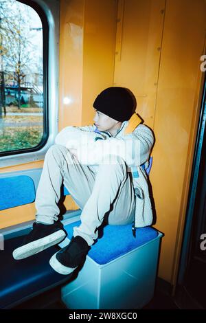 Contemplative boy looking through window while sitting in tram Stock Photo