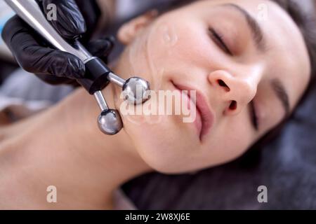 Cosmetology light equipment. Anti age and wrinkle. Microcurrent medicine treatment. Portrait of beautiful woman. Skincare clinic Stock Photo