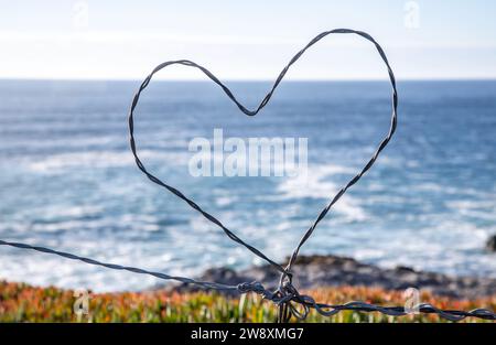 A heart made from barbed wire framing the Pacific Ocean. Wrights Beach is located on the west coast of Sonoma County in Northern California. Stock Photo