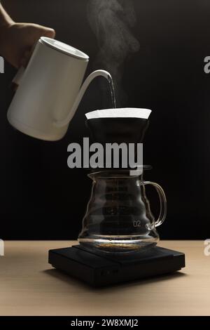 Pouring hot water through coffee grounds in a filter Stock Photo