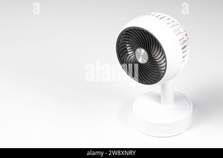 Small white plastic desktop fan side view, isolated on white background. Stock Photo