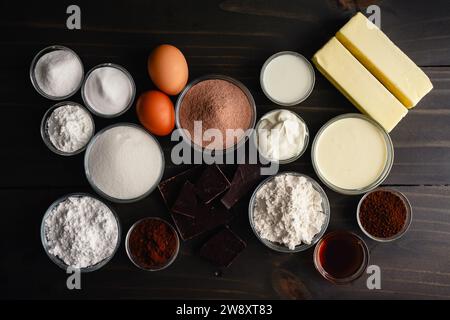 Hot Cocoa Cupcake Ingredients on a Wooden Table: Ingredients to make homemade hot chocolate flavored cupcakes with chocolate ganache filling Stock Photo