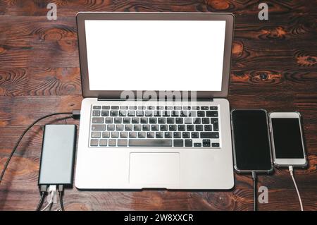 Set of gadgets. Laptop two smartphones and a powerbank. Programmer workplace concept. Top view. IT technologies. Mixed media Stock Photo