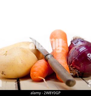 Basic vegetable ingredients carrot potato onion on a rustic wood table, food photography Stock Photo