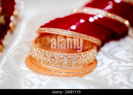 Close-up of traditional golden bangles on a red velvet background exuding luxury and elegance, Mauritius Stock Photo