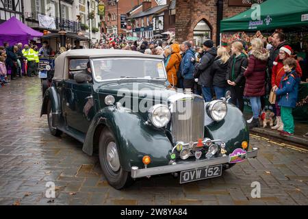 Lymm Dickensian Day 2023. People dressed in Dickensian costume; stalls in the streets; street entertainment; Grand Parade. Alvis car joins the parade Stock Photo