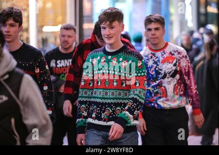 Birmingham 22nd December 2023 - Revellers took to Birmingham on Mad Friday which also goes by the name Black Eye Friday. Work party's were in full swing as businesses shut down for the Christmas holiday. Plenty were seen walking through the city centre holding a huge German Market glass of bier and many wore Santa hats. A group of 3 work buddies went to a Mexican restaurant for their do and two wore Mexican outfits with their colleague sticking to a traditional Santa hat. Friends were also spotted on Broad Street having a tussle at a tram stop with one holding another in a headlock. Another gr Stock Photo
