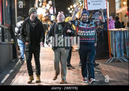 Birmingham 22nd December 2023 - Revellers took to Birmingham on Mad Friday which also goes by the name Black Eye Friday. Work party's were in full swing as businesses shut down for the Christmas holiday. Plenty were seen walking through the city centre holding a huge German Market glass of bier and many wore Santa hats. A group of 3 work buddies went to a Mexican restaurant for their do and two wore Mexican outfits with their colleague sticking to a traditional Santa hat. Friends were also spotted on Broad Street having a tussle at a tram stop with one holding another in a headlock. Another gr Stock Photo