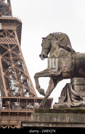 Horse statue at the foot of the Eiffel Tower in autumn in the rain in Paris - France Stock Photo