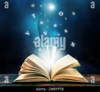 Open book with magic light and glowing letters flying out of it on wooden table against black background Stock Photo