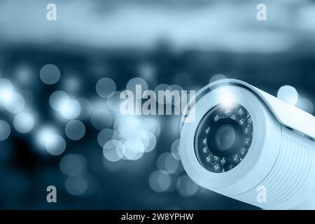 Modern security CCTV camera against blurred background, space for text Stock Photo
