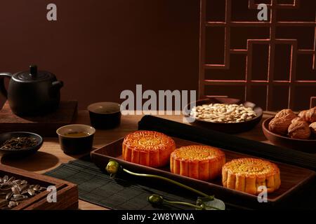 Chinese style photography for advertising. Wooden trays of mooncakes and types of seeds decorated on brown background with traditional window frames Stock Photo