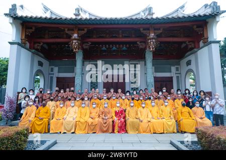 Bandung, Indonesia - January 8, 2022 : The monks sitting together for taking a photo in front of the Chinese gate inside the buddha temple Stock Photo