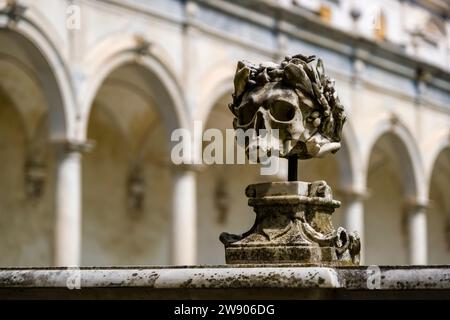 Marble sculpture of a skull at the inner courtyard of the former Carthusian monastery Certosa di San Martino, situated on a hill high above the town. Stock Photo