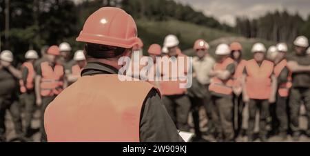 Worker group wearing vest, safety. Building concept. Architector, engineers on constructing site. Builder man Stock Photo