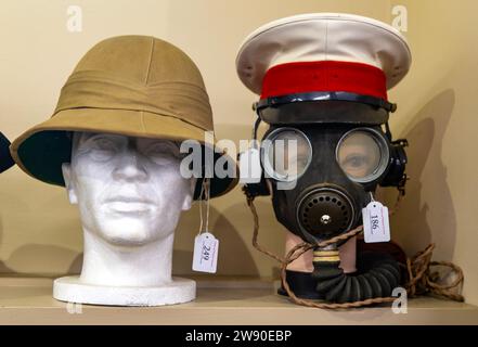 Pith helmet and gas mask on sale at auction of military memorabilia, UK Stock Photo