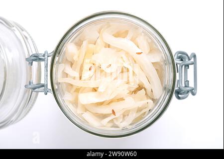 German sauerkraut, in an opened swing top glass jar. Cut raw cabbage, fermented by lactic acid bacteria. Traditionally a warm served side dish. Stock Photo