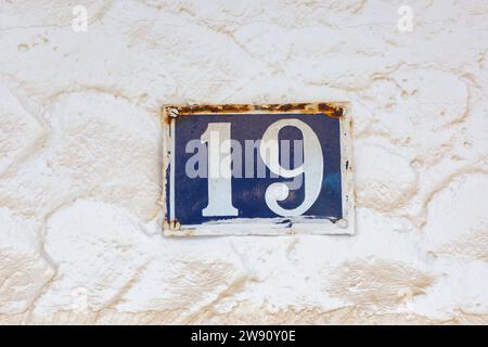 Old Weathered House Number 19, Tile on Wall Stock Photo