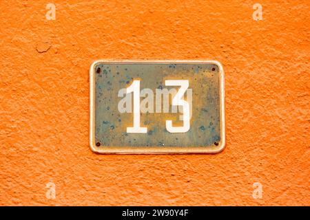 Old Weathered House Number 13, Tile on Wall Stock Photo