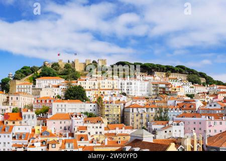 View across red rooftops of old houses towards Sao Jorge Castle on the hilltop. Lisbon, Portugal, Europe. Stock Photo
