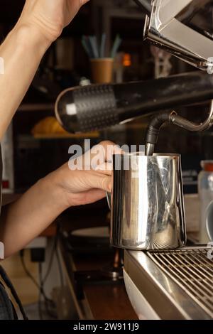 Close-up of barista pouring coffee from coffee machine in dark room of cafe store Stock Photo