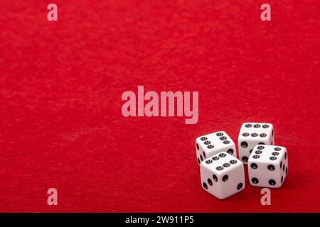 Four White Dice with Value 6 on Red Velvet Playing Table - Gambling and Game Concept for Luck and Chance Games Stock Photo