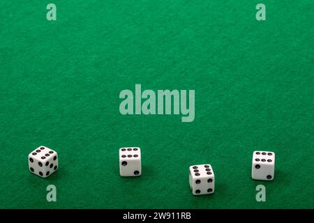 Four White Dice on Green Felt Background Stock Photo