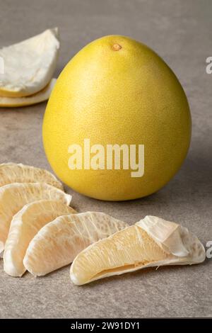 Whole fresh yellow Pomelo and peeled pomelo slices close up Stock Photo