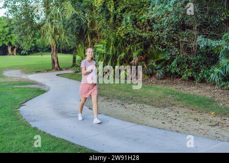 Active and determined, a pregnant woman maintains a healthy lifestyle, jogging with a focus on well-being and fitness during pregnancy Stock Photo