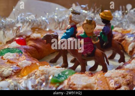The wise men on a camel in the center of a roscon de reyes decorated with candied fruit and tinsel around it Stock Photo