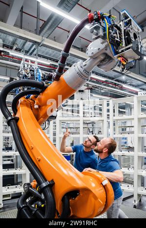 Two technicians examining industrial robot in a factory Stock Photo