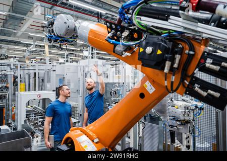 Two technicians examining industrial robot in a factory Stock Photo