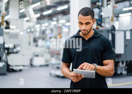 Technician using digital tablet on shop floor in a factory Stock Photo